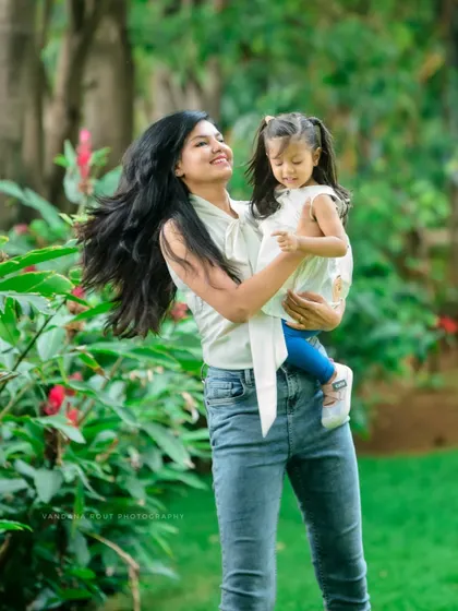 This candid shot from a Mom & Me session is full of life and movement. The mother's hair flies as she holds her daughter, both sharing a moment of pure happiness.