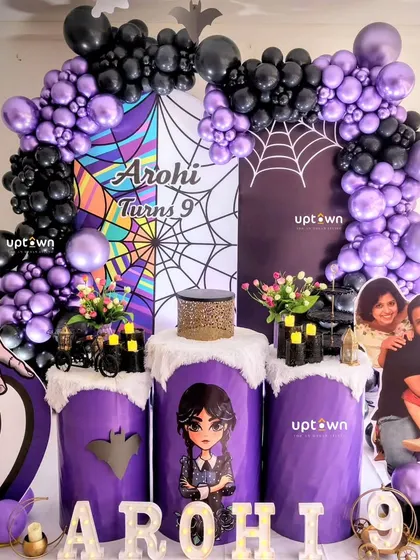 Another angle of the Wednesday party, showing the character cutouts and spiderweb backdrop.