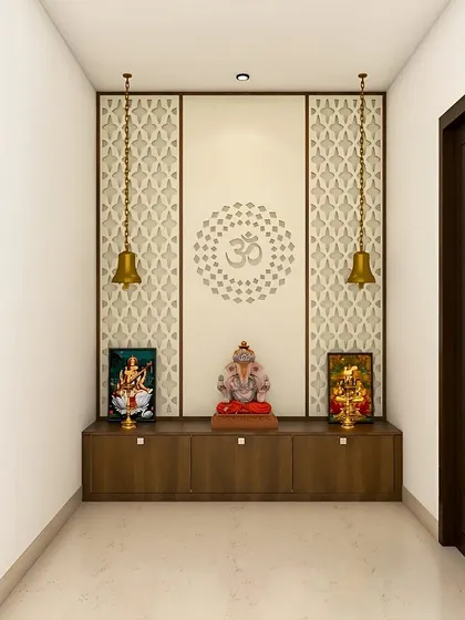A minimalist pooja space with a beautiful Om mandala on the back wall. The two hanging bells and simple wooden cabinet create a peaceful and balanced design.