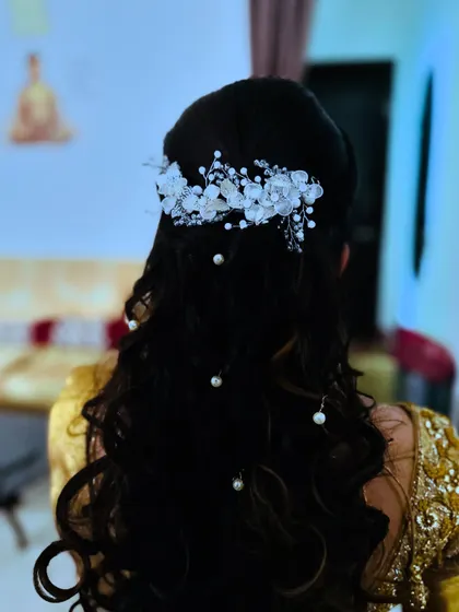 Another angle of this elegant reception hairstyle. The placement of the pearl accessories adds a touch of glamour to the flowing curls.