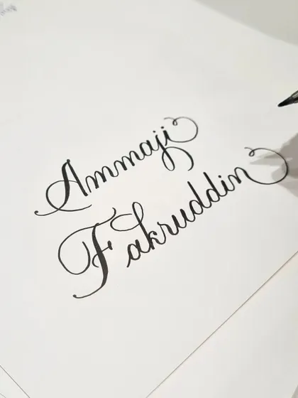 Practicing some names before the event rush. Preparation is key to ensuring every piece of calligraphy is crafted with care, even in a busy retail environment.