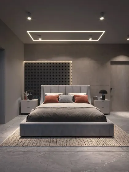 A modern bedroom with a moody, sophisticated aesthetic. The design features a grey upholstered bed, a perforated headboard panel, and dramatic linear lighting.