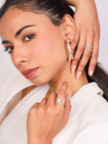 This shot for Diamond Jewel showcases multiple rings and earrings. The model's hands frame her face, creating a composition that is both a portrait and a detailed accessory shot.