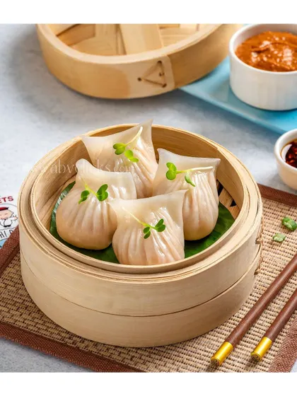 Translucent crystal shrimp dumplings served in a traditional bamboo steamer, highlighting their delicate texture and filling.