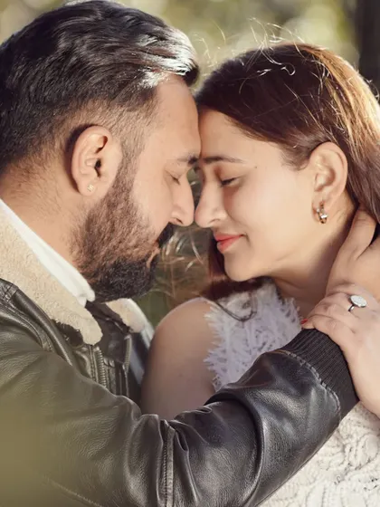 A close-up, intimate portrait of a couple from their pre-wedding shoot. The focus is on their gentle expressions and the connection between them.