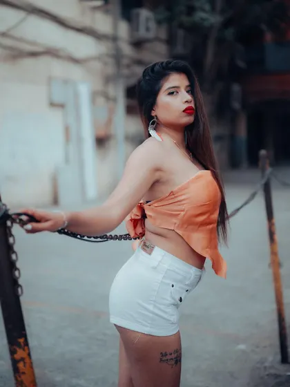 A confident street style portrait. The model's pose and the urban background create a bold and fashionable image, perfect for an influencer portfolio.