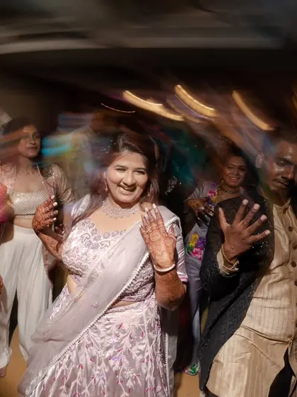 A candid shot of the bride enjoying the sangeet, surrounded by her dancing friends.