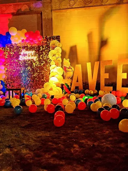 Another angle of the "AVEER" light-up letters at the Pooh-themed party. These large, illuminated letters add a personalized and impressive touch to any birthday celebration.