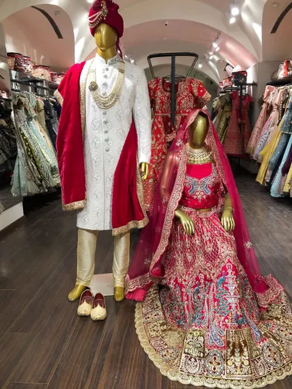 A timeless choice for the big day. This classic red bridal lehenga with intricate embroidery, paired with a regal white and gold sherwani, is a stunning combination for a traditional wedding ceremony.