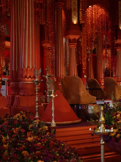 The rich textures and colors of the 'Lal Bagh' mandap, with deep red pillars and mounds of sindoor creating a powerful visual.