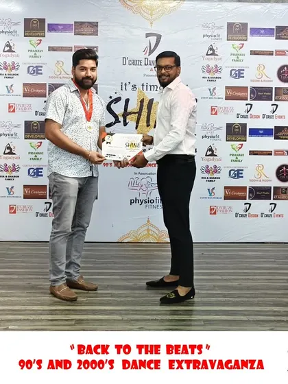 A participant receiving his award at the "Back to the Beats" event.