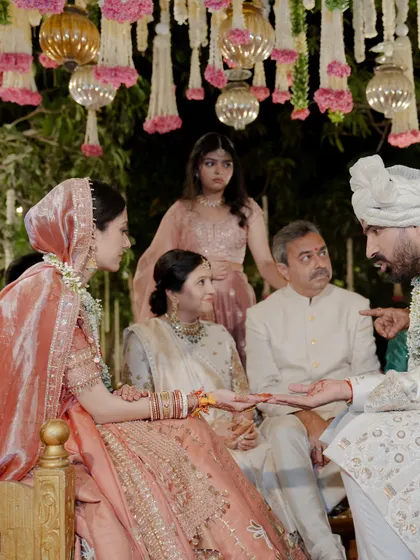 A candid shot from the mandap, showing the bride, groom, and their parents, all styled in a harmonious color palette.