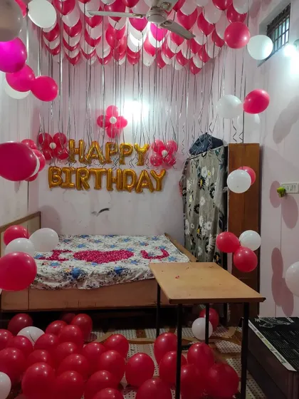 Another view of the pink and white birthday room decoration, with balloons covering the floor.