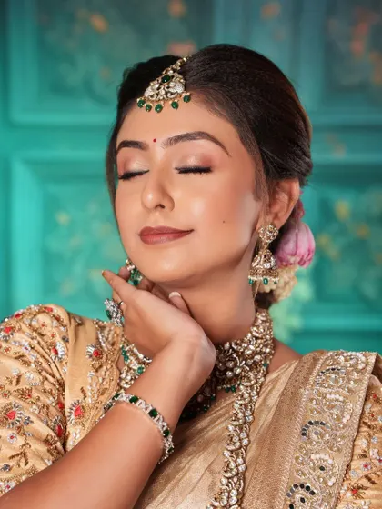 The soft, elegant makeup complements the grandeur of the Polki jewellery set.