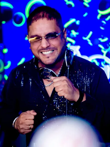 A big smile and a sequined shirt. This look is all about bringing positive, high-energy vibes to the DJ booth.