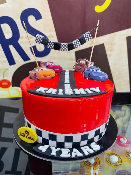 A 1.5kg Disney Cars cake with a glossy red finish and a mini race on top.