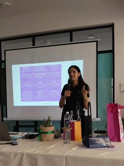 Presenting at a workshop, with a slide on emotional intelligence visible in the background. I use a mix of presentation, discussion, and activities to create a dynamic learning environment.