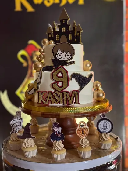 The main event. A two-tiered Harry Potter cake with our personalized topper featuring a chibi Harry, Hogwarts castle, and the golden snitch.