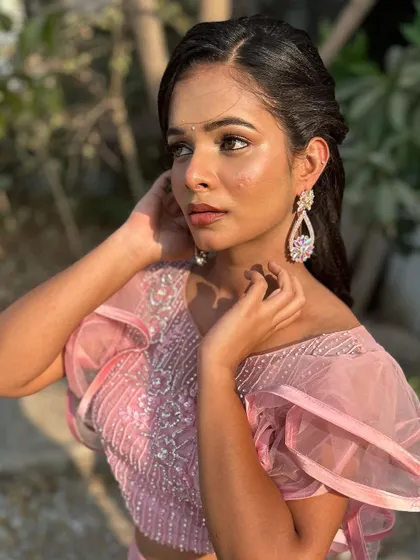 A classic pose that highlights the elegant hairstyle and the soft, romantic makeup.