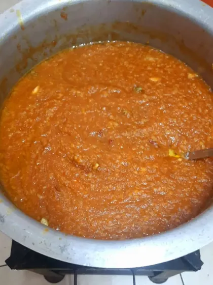 A large pot of sakkare pongal, or sweet pongal, being prepared for an event. This traditional sweet dish is made with rice, lentils, jaggery, and ghee.