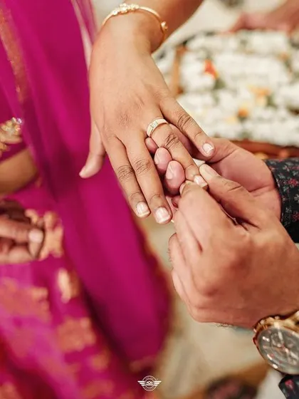 The ring exchange. A close-up shot of this pivotal moment during an engagement ceremony, full of promise and love.