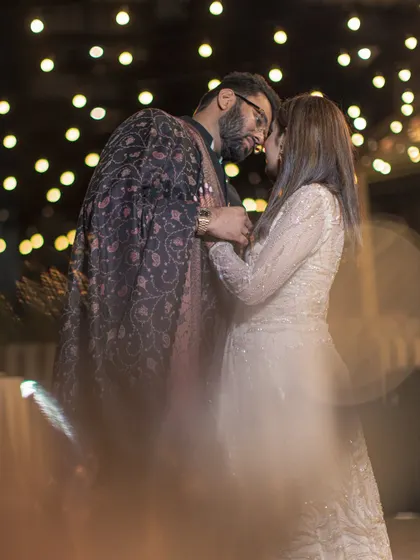 An artistic and romantic shot of the couple embracing, with soft focus and bokeh lights creating a dreamy, magical atmosphere.