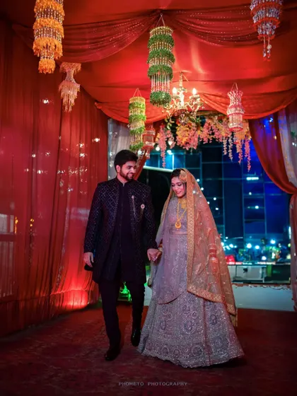 The couple makes their entrance at the reception, hand in hand, walking down a beautifully decorated path.