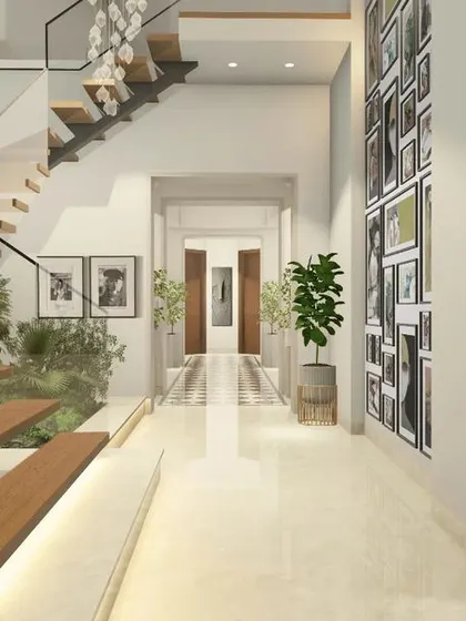 A bright hallway featuring a floating staircase with glass railings and an indoor planter, enhancing the home's connection to nature. A large gallery wall provides a canvas for personal art collections.