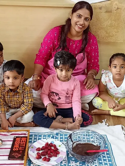 Getting ready to make some delicious chocoberry bites. The children are gathered around the ingredients, including fresh strawberries and chocolate, ready for another fun kitchen activity.