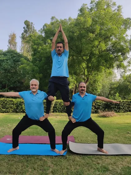 A three-person acro yoga pyramid during our outdoor session on International Yoga Day. This demonstrates incredible strength, balance, and teamwork.