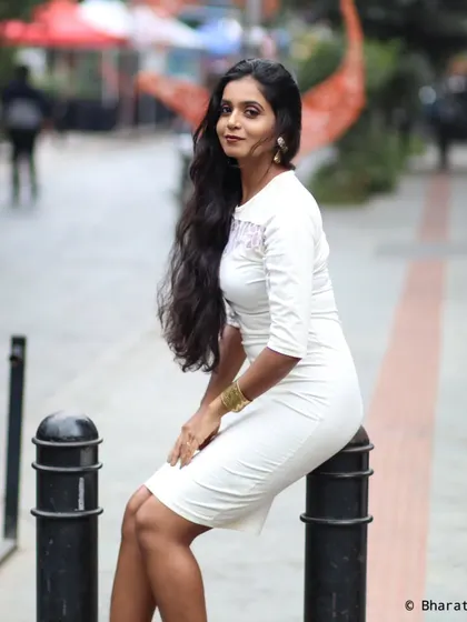 A full-length urban portrait, using city bollards as a prop for a seated pose. This is a great way to interact with the environment.