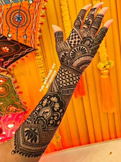 This bridal arm design showcases a variety of techniques, including negative space florals, geometric grids, and traditional Indian motifs, all coming together in one harmonious piece.