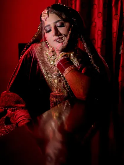 An artistic bridal portrait using dramatic red lighting. This creative shot adds a touch of glamour and mystery to the bridal album.