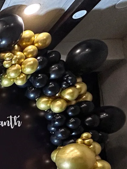 A close-up of a black and gold chrome balloon arch. This classic and elegant color combination is perfect for milestone birthdays, anniversaries, or any sophisticated event.