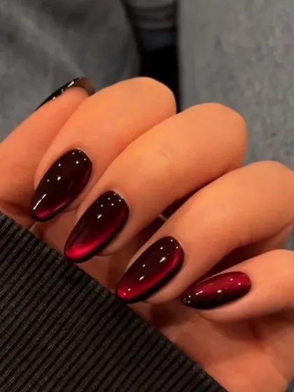 A close-up of these amazing "cat eye" or "velvet" nails in a deep red shade. The effect is mesmerizing.