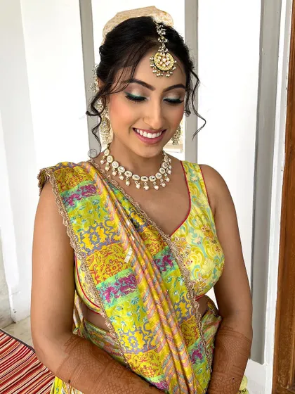 Embracing the intricate beauty of tradition with this mesmerizing Mehendi makeup look. The soft glam makeup lets her beautiful smile and outfit be the focus.
