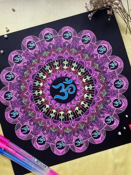 An Om mandala created with glowing pinks and purples on black paper. This piece combines spiritual symbolism with the vibrant energy of neon colors.