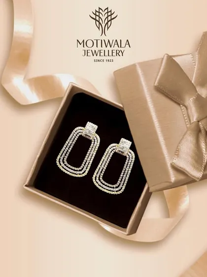 A pair of modern, rectangular diamond hoop earrings presented in a gift box. This image evokes the excitement of giving or receiving a piece of timeless jewellery.