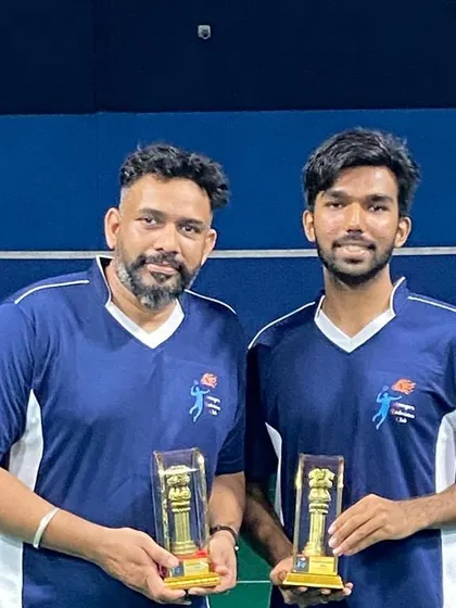 Two players from a winning team posing with their trophies.