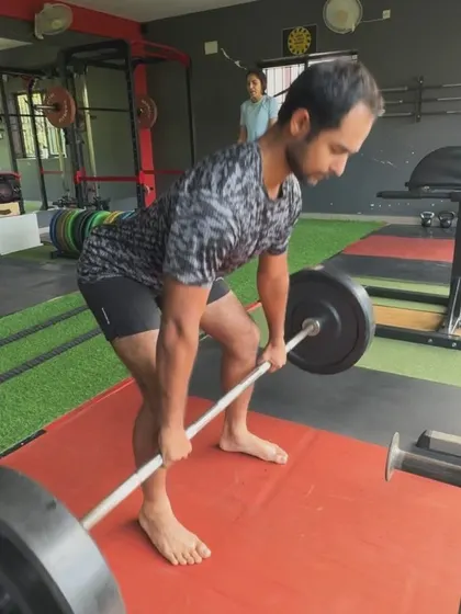 A client performs a barefoot deadlift, which can help improve foot stability and connection to the ground during the lift.