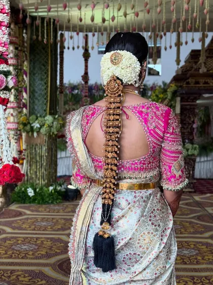 A full view of the magnificent bridal braid, showcasing the intricate details of the temple jewellery against the rich silk saree. This is a perfect example of a classic South Indian wedding hairstyle.