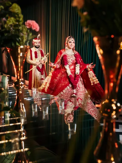 An artistic shot of the couple on a reflective floor, creating a stunning mirror image. This creative composition adds a touch of magic and grandeur to their wedding portrait.