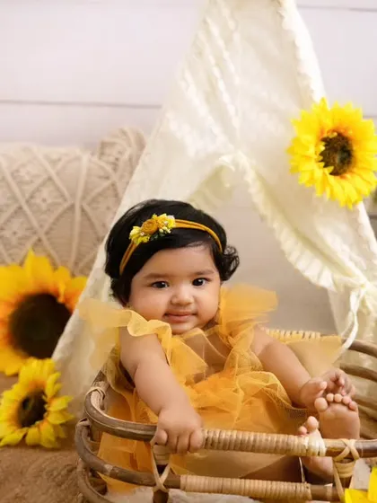 Sitting pretty in a basket surrounded by sunflowers. This setup is perfect for babies who have just learned to sit up on their own.