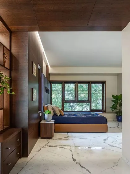 This bedroom in Kanasu features custom wood cabinetry and large windows, creating a serene space that feels connected to the outdoors.