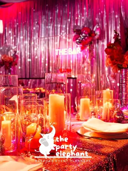 The tablescape for the disco party was bathed in a vibrant pink glow, with candles, disco ball accents, and a sequined tablecloth creating a glamorous and immersive dining experience.