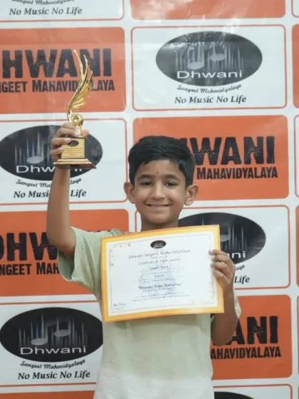 A young winner triumphantly holds his trophy high.
