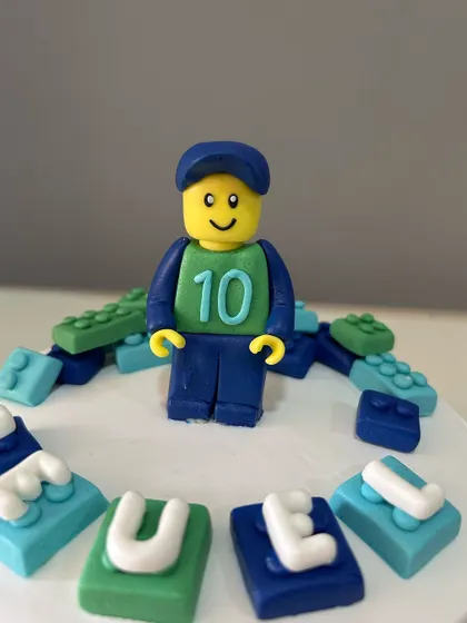 A close-up of the personalized Lego character topper, complete with the birthday boy's age on the shirt.