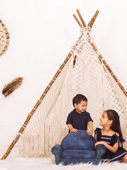 A playful interaction between siblings inside the studio teepee. These are the candid moments that families will cherish for years to come.