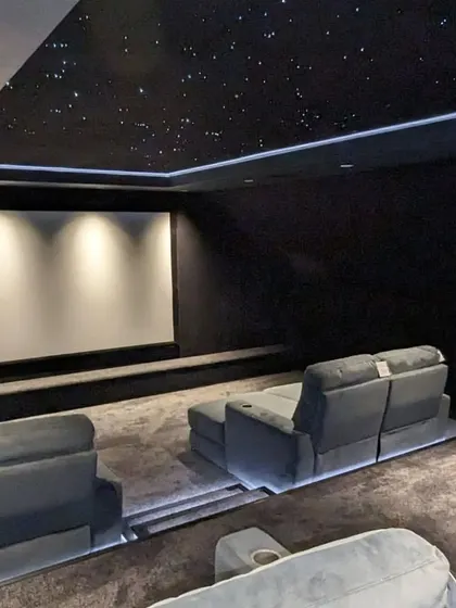 The screen is off, but the ambient lighting from the star ceiling and step lights creates a relaxing and luxurious atmosphere.