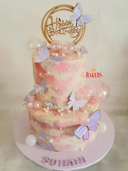 A completely no-fondant butterfly theme cake for a birthday celebration. The pink and purple marble effect with delicate wafer paper butterflies creates a dreamy and whimsical look.